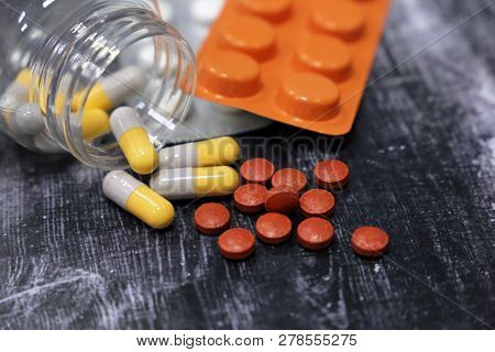 Pills In Capsules And Blister On Dark Wooden Table, Medication Close-up. Concept Of Pharmacy, Flu Tr