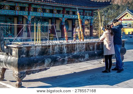 Married Couple Near The Censer Set Fire The Joss Aroma Incense Sticks Or Candles In Hua-yang Temple