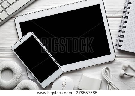 White Modern Digital Tablet And Smartphone, Headphones, Computer Mouse And Keyborad On White Backgro