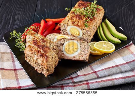 Meatloaf Bolo De Carne Alemao Served With Red Pepper And Avocado Slices On A Black Rectangular Platt