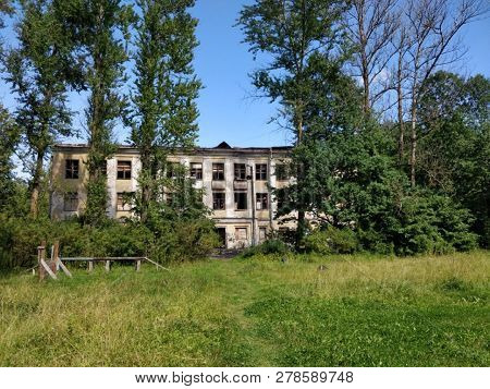 Old Destroyed Windowless Building With Green Trees