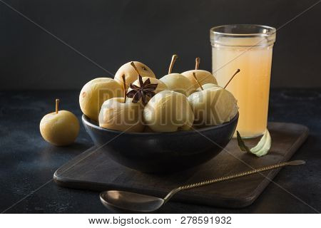 Pickled Apples In Bowl And Apple Sidr On Dark Stone Table.