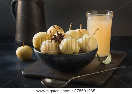 Pickled Apples In Bowl And Apple Sidr On Dark Stone Table.
