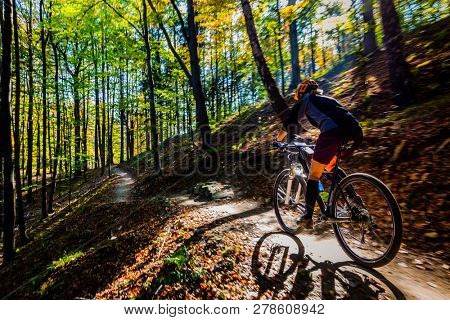 Cycling woman riding on bike in spring summer mountains forest landscape. Woman cycling MTB flow trail track. Outdoor sport activity.
