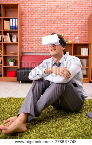 Young employee with virtual glasses during break in the office 