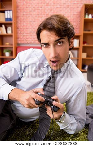 Young employee playing joystick games during his break 