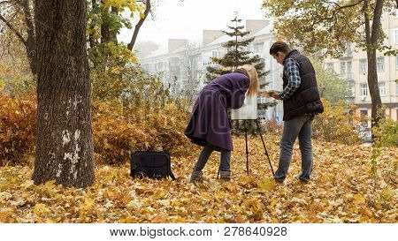 Young Girl Artist Teaching A Sudent How To Draw In The Autumn Park