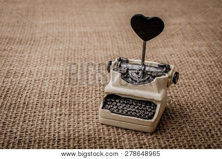 Retro Syled Tiny Typewriter Model On A Canvas Background