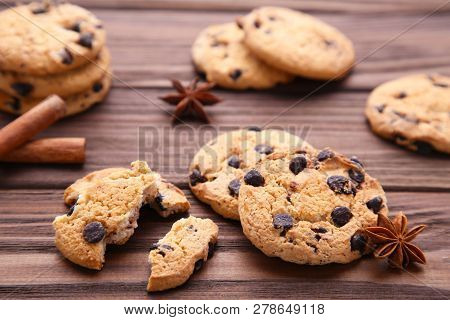 Delicious Chocolate Cookies On Brown Background. Chocolate Cookies And Cinnamon Sticks.