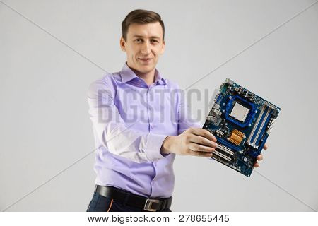 Young Man With Motherboard In His Hands Is Isolated On Light Background
