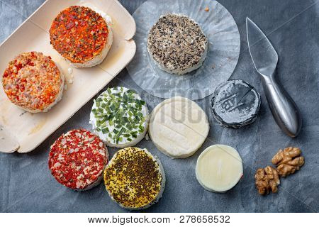 Assortment Of French Fresh White Soft Goat Cheeses With Different Tastes Topping Made With Herbs, Pa