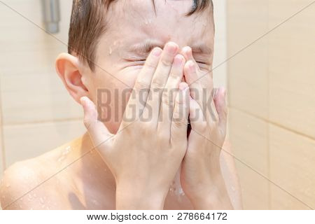 A Preteen Boy Wiping His Face With Hands After Shower Or Bath.