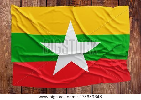 Flag Of Myanmar - Burma On A Wooden Table Background. Wrinkled Burmese Flag Top View.