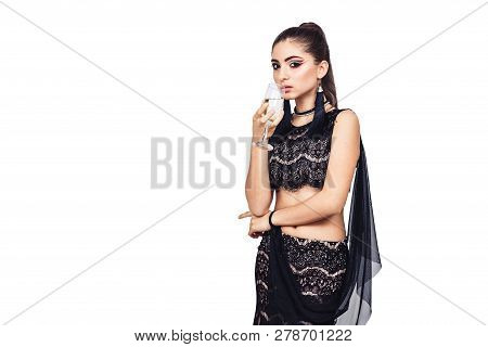 Elegant Young Girl Holding A Glass Of Champagne Near The Mouth. Isolated On White