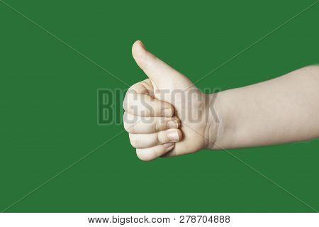 Children's Hand Shows A Sign. Isolated On Green Background