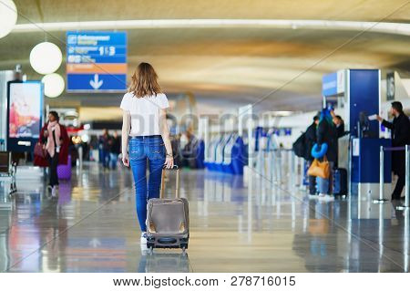 Young Woman In International Airport Walking With Luggage, Ready For Her Flight