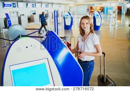 Young Woman In International Airport Doing Self Check-in