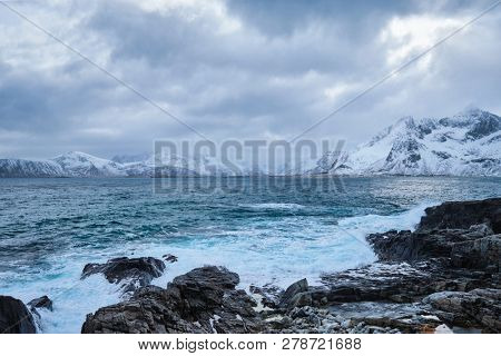 Waves of Norwegian sea crushing at rocky coast in fjord. Vikten, Lofoten islands, Norway