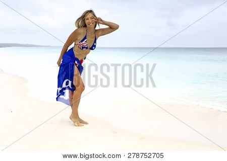 Australian Woman Beach Vibes. Standing On Idyllic Beach Wearing Aussie Flag Sarong And Bikini Patrio