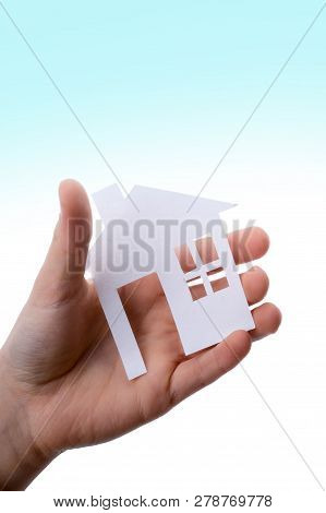 Hand Holding An Isolated Paper House With A White Background