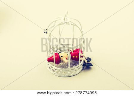 Metal Cage And Little Puppet Pinocchio Made Of Wood
