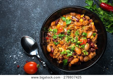 Chili Con Carne From Meat, Beans And Vegetables On Black Stone Table. Traditional Mexican Food. Top 