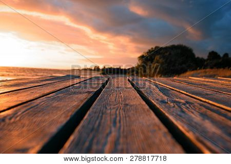 Close Up Top Wooden Table And Blur Sunset Background. Tonted Orange.