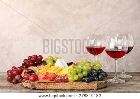 Composition With Wine And Snacks On Wooden Table