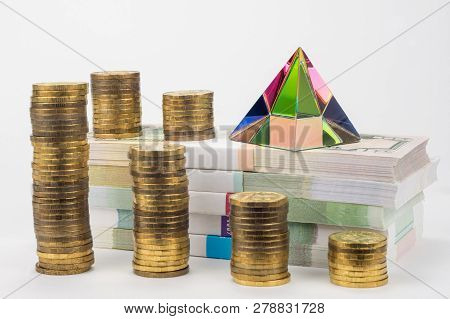 Stacks Of Coins, Bundles Of Notes And A Glass Pyramid