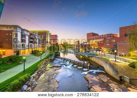 Greenville, South Carolina, USA downtown cityscape on the Reedy River at dusk.