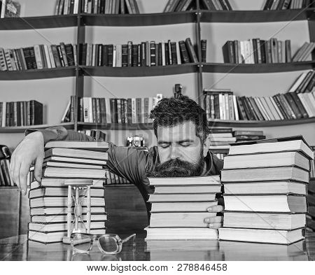 Man On Sleeping Face Lay Between Piles Of Books, Fall Asleep While Studying In Library, Bookshelves 