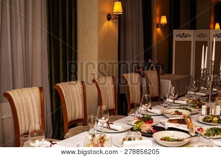 Empty Glasses Stand Near Plates And Forks On Banquet Table Decorated With White Tablewear