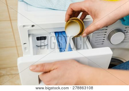 Washing Powder Detergent And Measuring Cup Pouring Into Machine. Household Duties, Clothes Laundry O