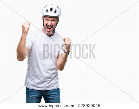 Middle age senior hoary cyclist man wearing bike safety helment isolated background very happy and excited doing winner gesture with arms raised, smiling and screaming for success. Celebration concept