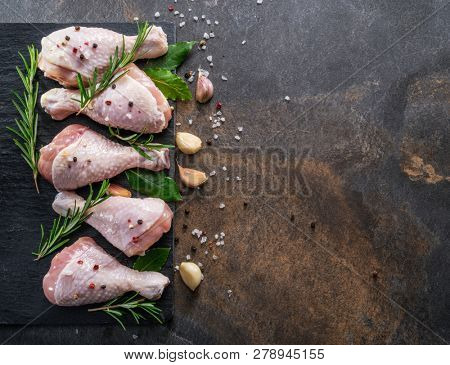 Chicken legs with spices and salt  ready for cooking on cutting board.