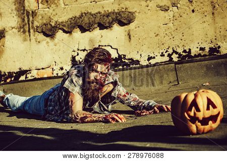 Bearded Zombie Man With Beard Creepy Vampire Or Bloody War Soldier With Wounds And Red Blood Lies On