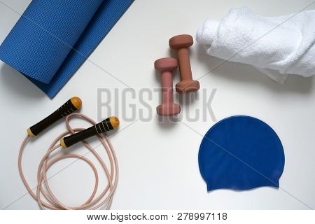 Jump Rope, Yoga Mat, Dumbbells, White Bath Towel, Swimming Cap, Close-up On A White Background