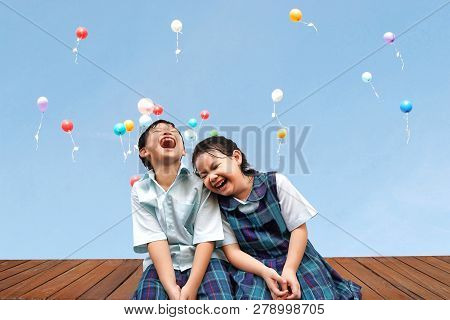 Funny Asian Little Kids Brother And Sister Sitting On The Wooden Terrace With Colourful Balloons Bac