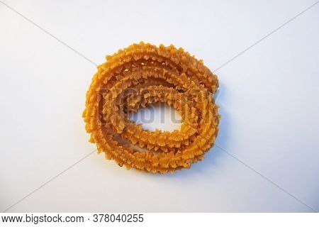 A Top Shot Of Spiral Shaped Chakali Crispy Snack On White Background