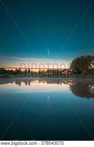 Dobrush, Belarus. Comet Neowise C2020f3 In Night Starry Sky Reflected In Small Lake Waters