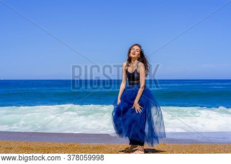 Hossegor, France. 30.06.2020. Beautiful Girl Posing Near The Wavy Ocean. Landscape Blue Background. 