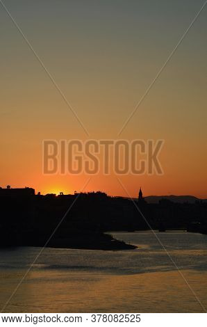 A Clear Sky Is Filled With The Colours Of Sunset. The River Arno Is In The Foreground, While The Olt