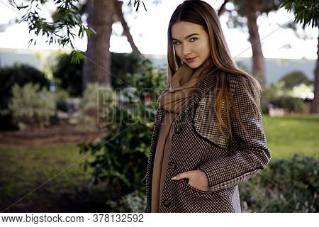 Young Long Hair Woman Model Of Clothes In The Garden In Spring Posing