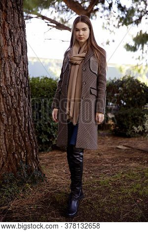 Young Long Hair Woman Model Of Clothes In The Garden In Spring Posing
