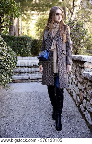 Young Long Hair Woman Model Of Clothes In The Garden In Spring Posing