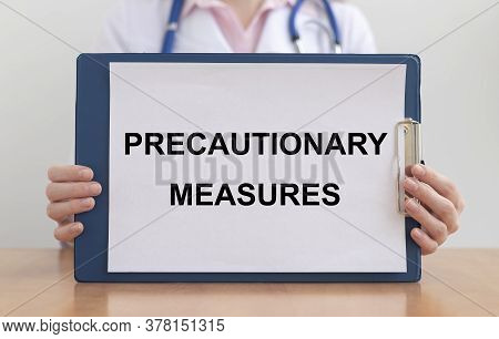 Female Doctor Holds Paper Board With Text Words Precautionary Measures