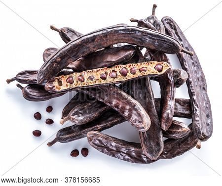 Carob pods and carob powder on the white background.