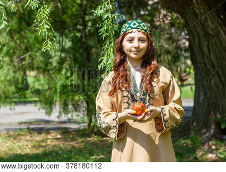 Armenian Young Woman In Traditional Clothes In The Forest With Pomegranate