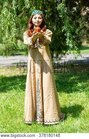 Armenian Young Woman In Traditional Clothes In The Forest With Pomegranate