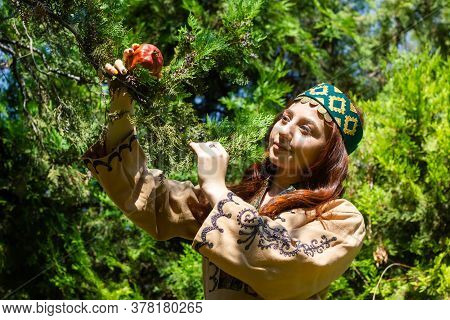 Armenian Young Woman In Traditional Clothes In The Forest With Pomegranate